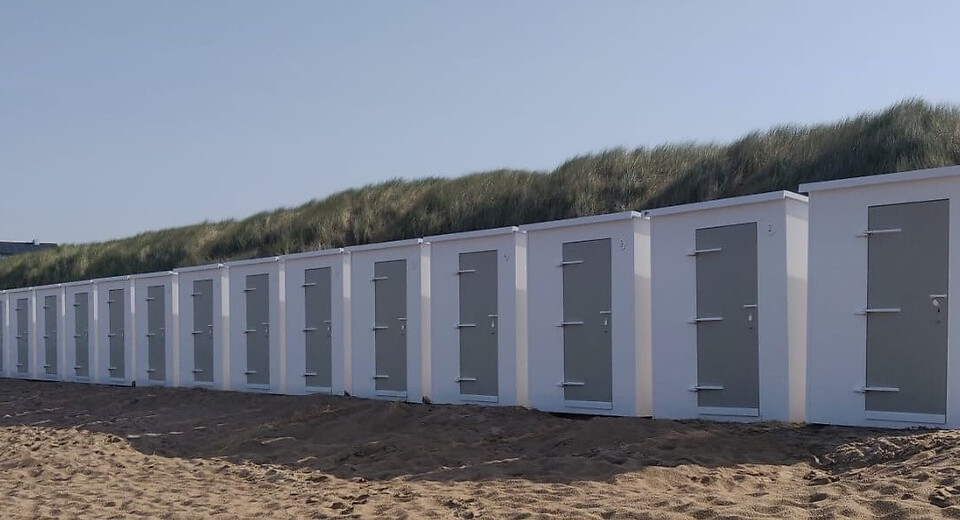 Rij kunststof strandhuisjes op het strand